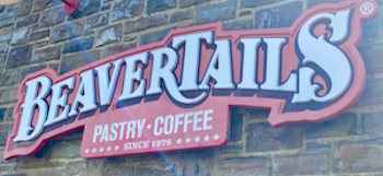Beaver Tails pastry and coffee sign on a brick wall