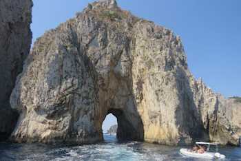 Capri Faraglionli Rock with cutout and boats driving through the arch