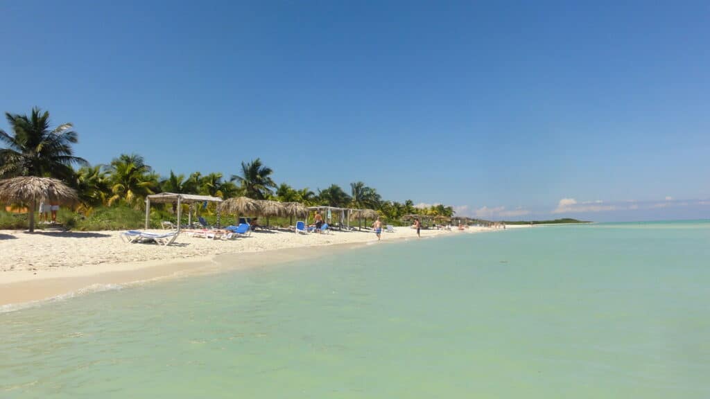 Cuba beach with clear turquoise water and beach beds on white powder sand