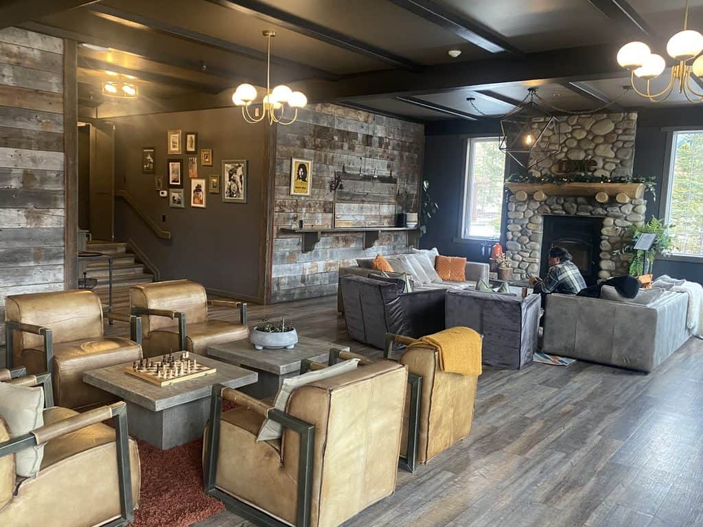 Interior of Creekside Villas great room with wood fireplace, cozy lounge chairs and games room