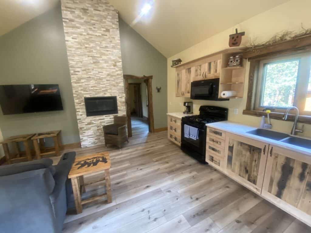 Interior kitchen of Bearberry Cabins Wolf cabin with fireplace kitchen with microwave and stove and living room with television