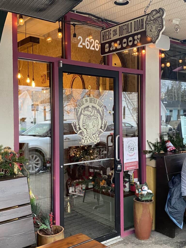 Glass door to restaurant with a sign that says Where the Buffalo Roam Saloon