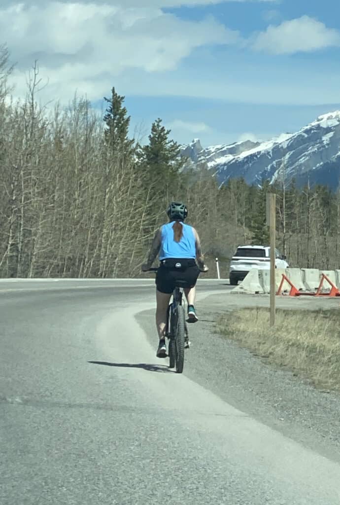 Woman biking on a road in the mountains
