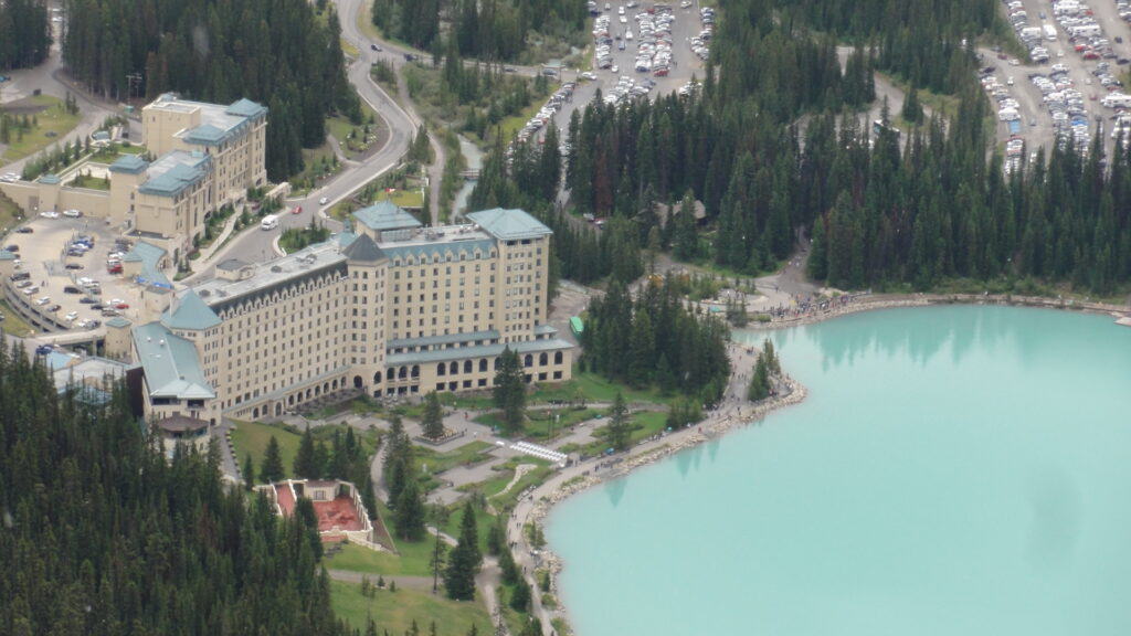 Fairmont Chateau Lake Louise hotel and green waters of Lake Louise from above