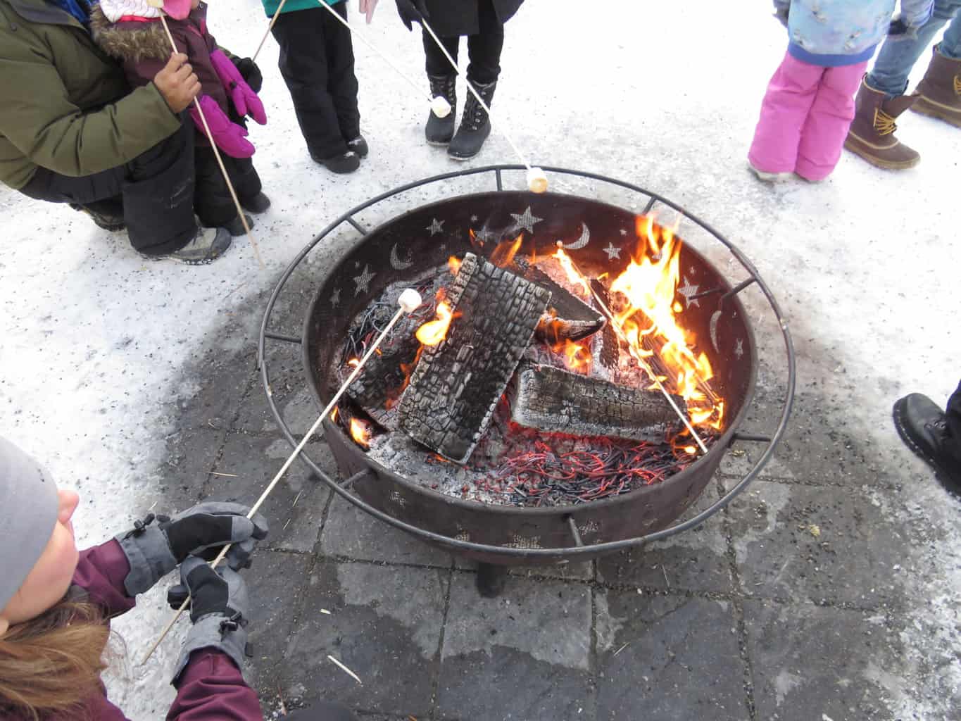 Roasting marshmallows atop and outdoor wood firepit at Lake Louise